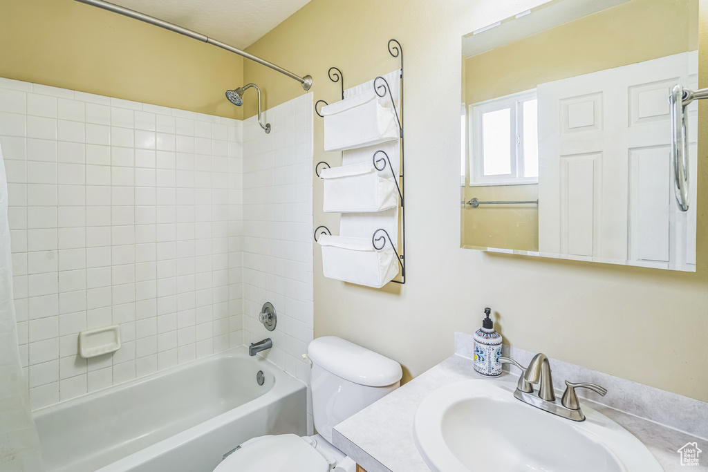 Full bathroom featuring vanity, shower / bath combo with shower curtain, and toilet