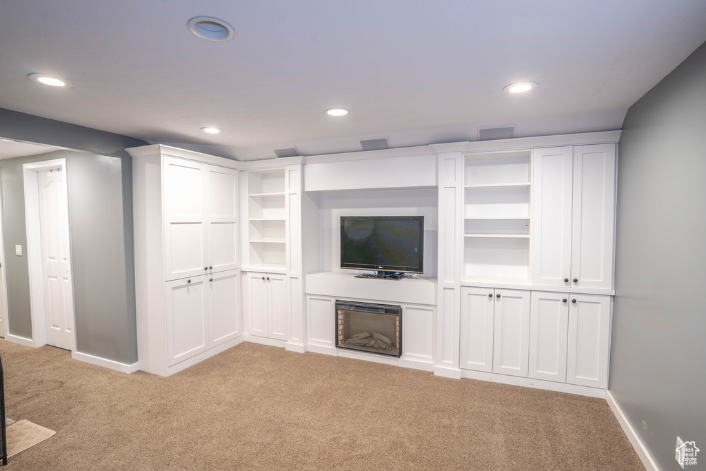 Unfurnished living room with light colored carpet, recessed lighting, and baseboards
