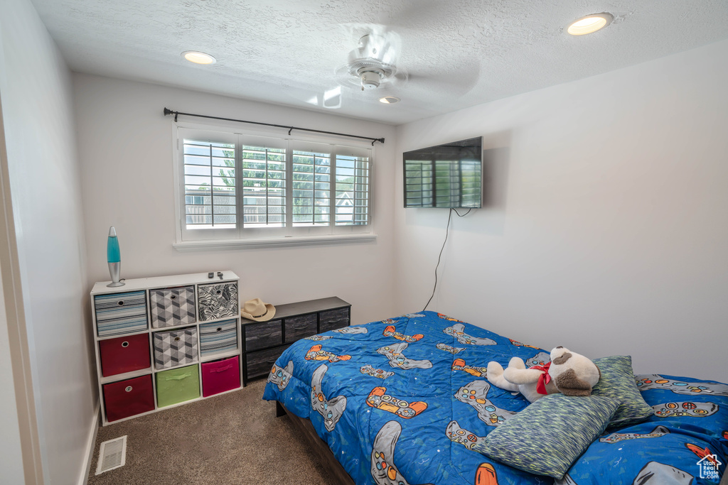 Bedroom with ceiling fan, a textured ceiling, visible vents, carpet, and recessed lighting