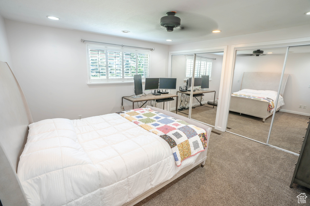 Carpeted bedroom with two closets, recessed lighting, and a ceiling fan
