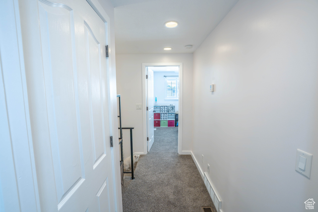 Hall featuring recessed lighting, baseboards, visible vents, and dark colored carpet