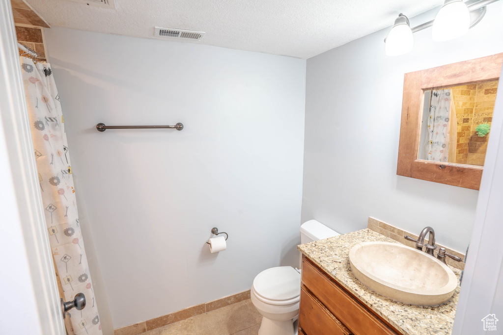 Bathroom featuring visible vents, vanity, curtained shower, toilet, and tile patterned floors