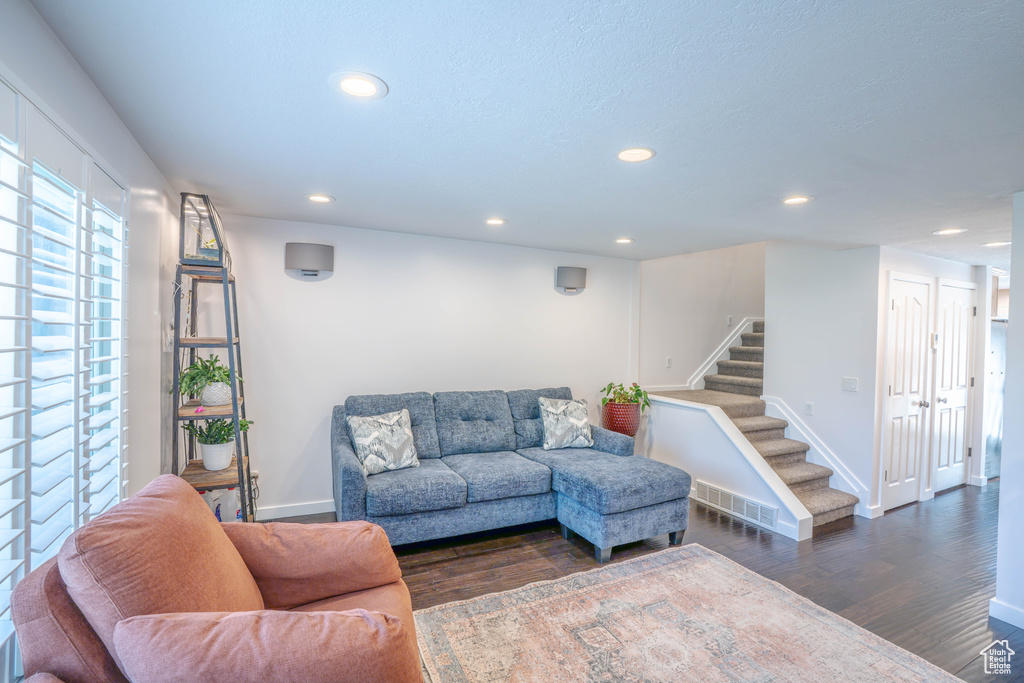 Living area featuring visible vents, dark wood finished floors, stairs, baseboards, and recessed lighting
