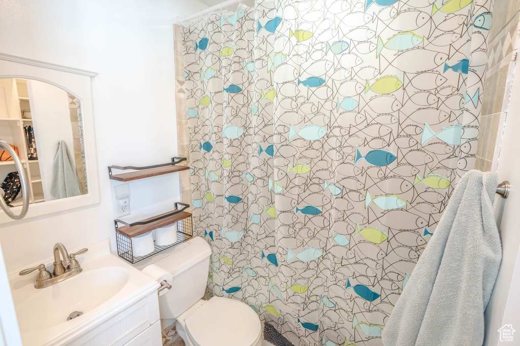Bathroom featuring vanity, a shower with shower curtain, and toilet