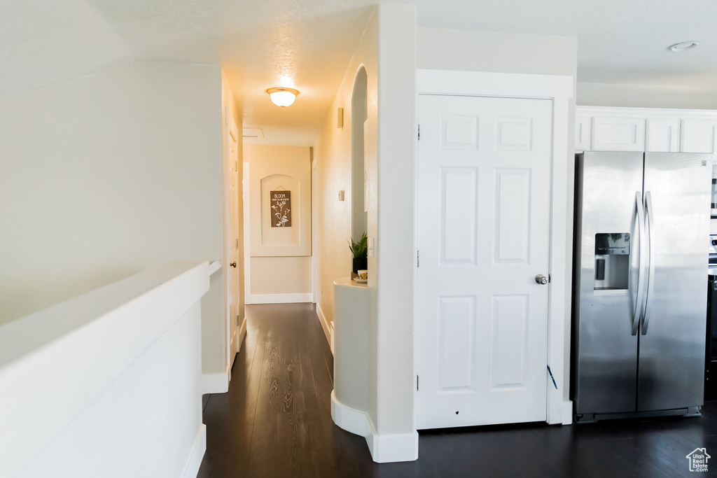 Hallway with baseboards and dark wood-style flooring