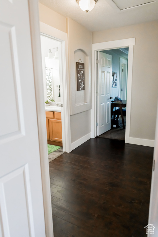 Hall featuring baseboards and dark wood finished floors
