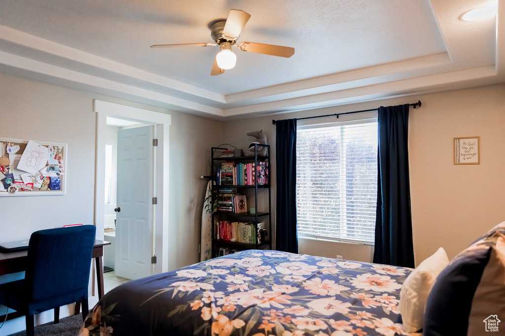Bedroom featuring a tray ceiling and ceiling fan