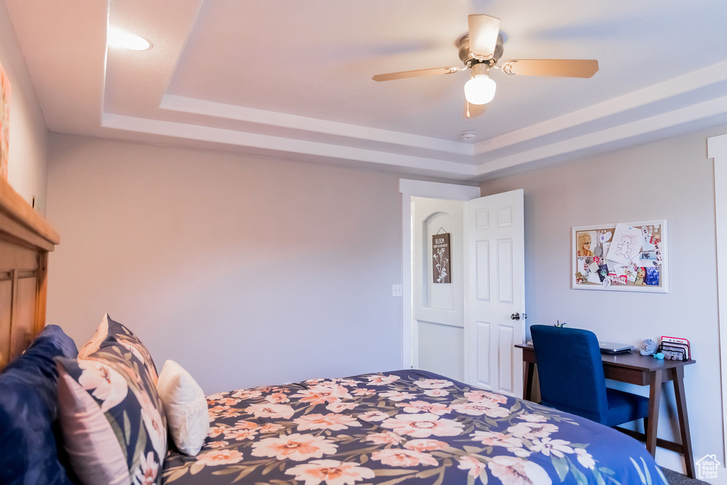 Bedroom featuring a tray ceiling and ceiling fan