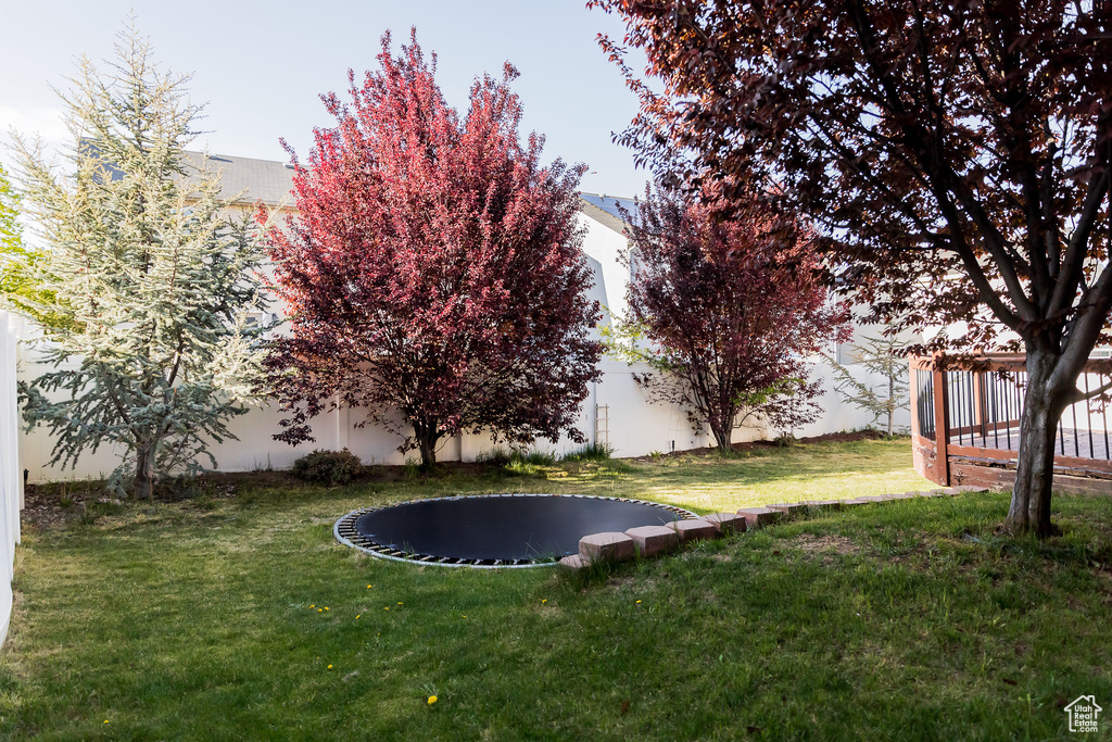 View of yard featuring fence and a trampoline