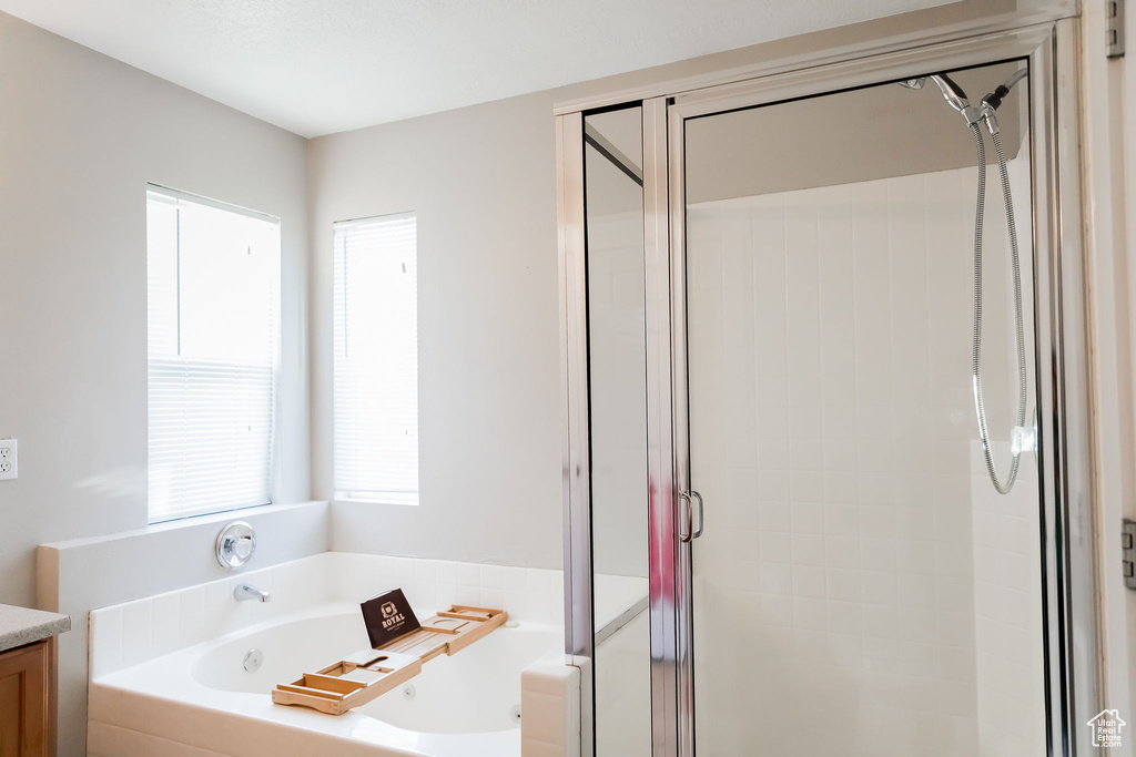 Full bath with vanity, a bath, and a shower stall