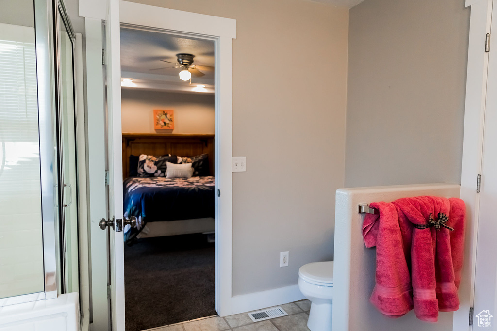 Bathroom featuring visible vents, toilet, baseboards, ceiling fan, and ensuite bath