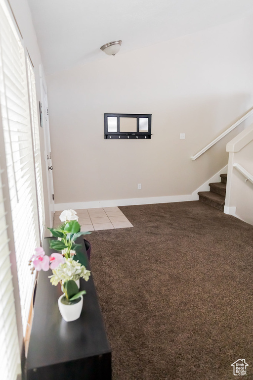 Interior space featuring stairs, tile patterned floors, vaulted ceiling, and plenty of natural light