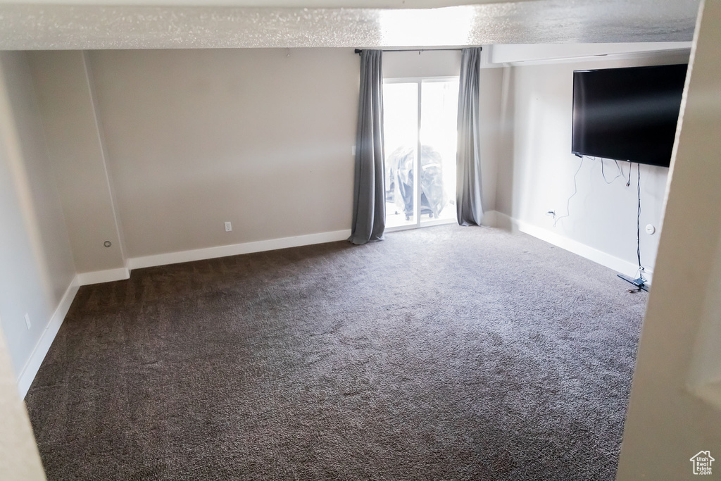 Spare room featuring baseboards and carpet