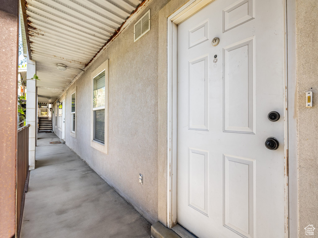 View of exterior entry with visible vents and stucco siding