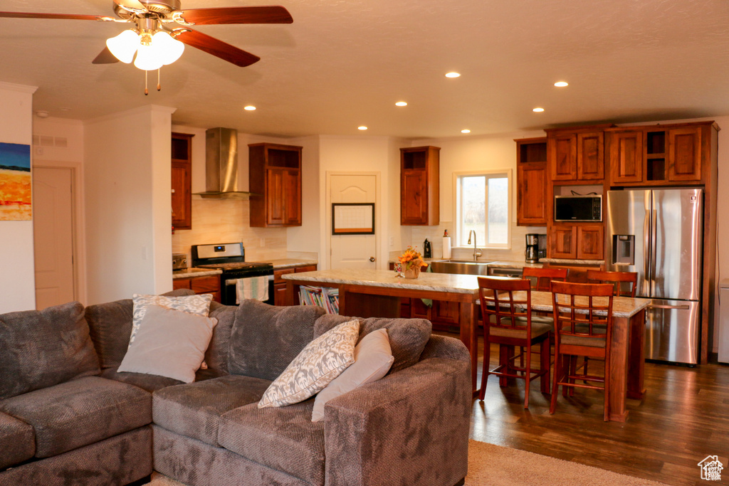 Living room featuring recessed lighting, a ceiling fan, and dark wood-type flooring