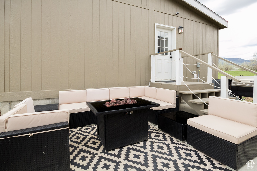 View of patio featuring an outdoor living space with a fire pit, stairs, and a mountain view