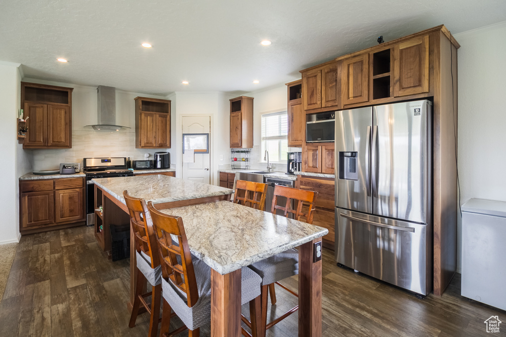 Kitchen featuring open shelves, stainless steel appliances, wall chimney exhaust hood, a sink, and dark wood-type flooring