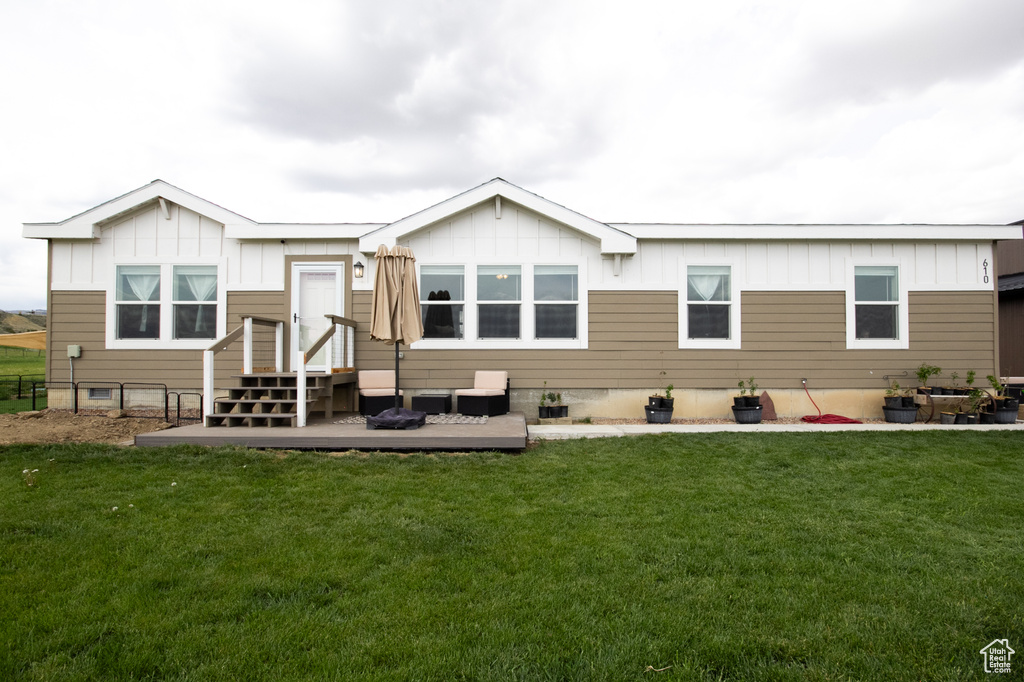 Back of house featuring board and batten siding and a yard