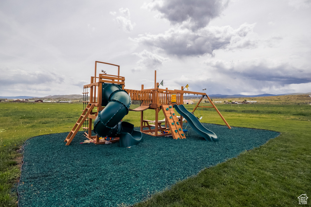 View of playground with a yard and a mountain view