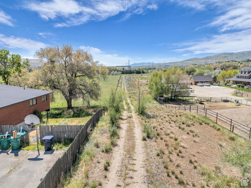 View of yard with a mountain view, fence, and a rural view