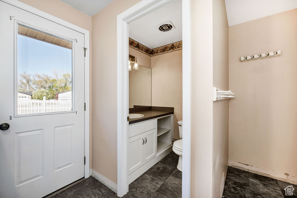 Bathroom with vanity, toilet, marble finish floor, baseboards, and visible vents