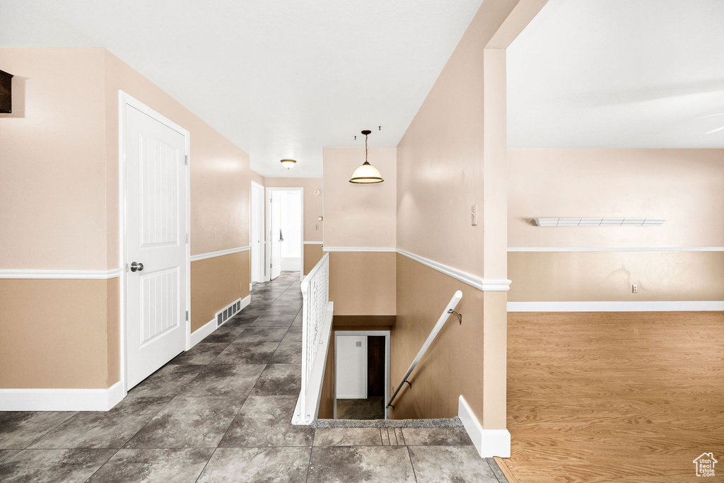Hall with baseboards, an upstairs landing, and visible vents