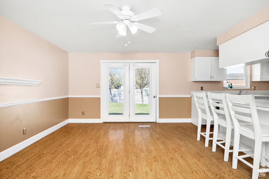 Unfurnished dining area featuring baseboards, light wood finished floors, ceiling fan, and visible vents