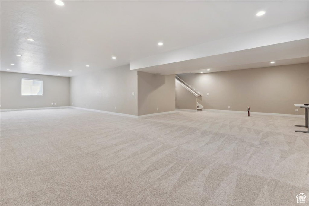 Basement featuring stairs, recessed lighting, baseboards, and light carpet