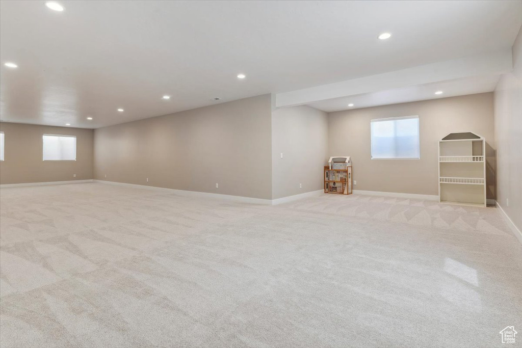 Below grade area with baseboards, light carpet, and recessed lighting