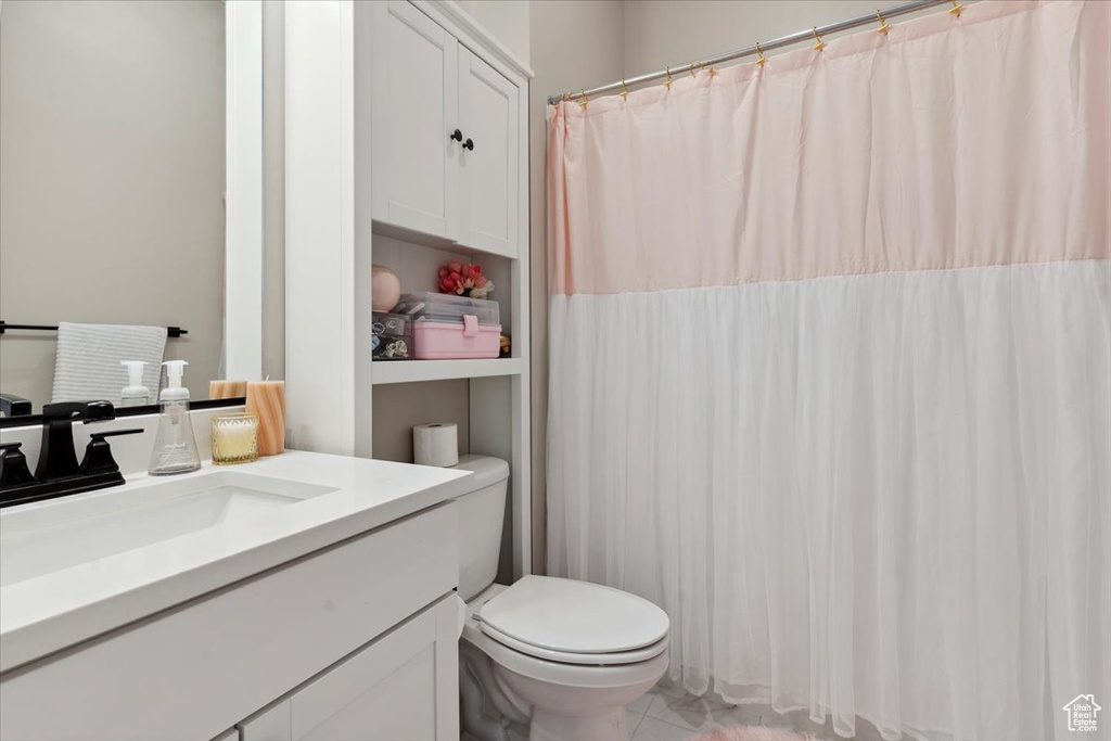 Full bathroom featuring toilet, curtained shower, and vanity