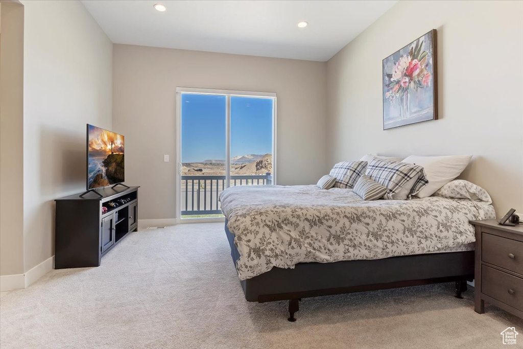 Bedroom with light colored carpet, access to outside, and baseboards