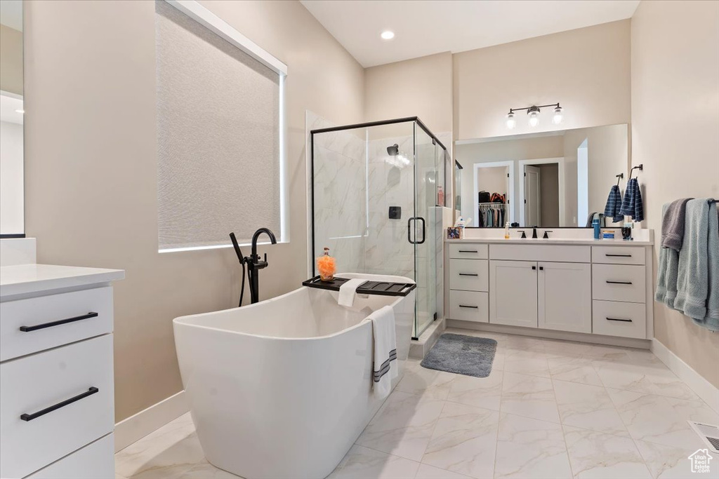 Full bathroom featuring a shower stall, a soaking tub, marble finish floor, and vanity