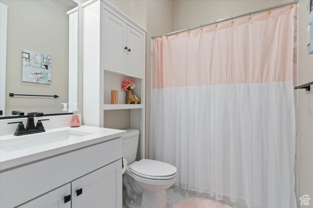 Full bathroom featuring toilet, vanity, a shower with curtain, and tile patterned floors