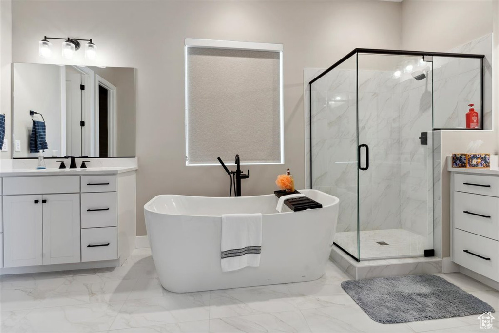 Bathroom featuring a freestanding tub, a marble finish shower, and marble finish floor