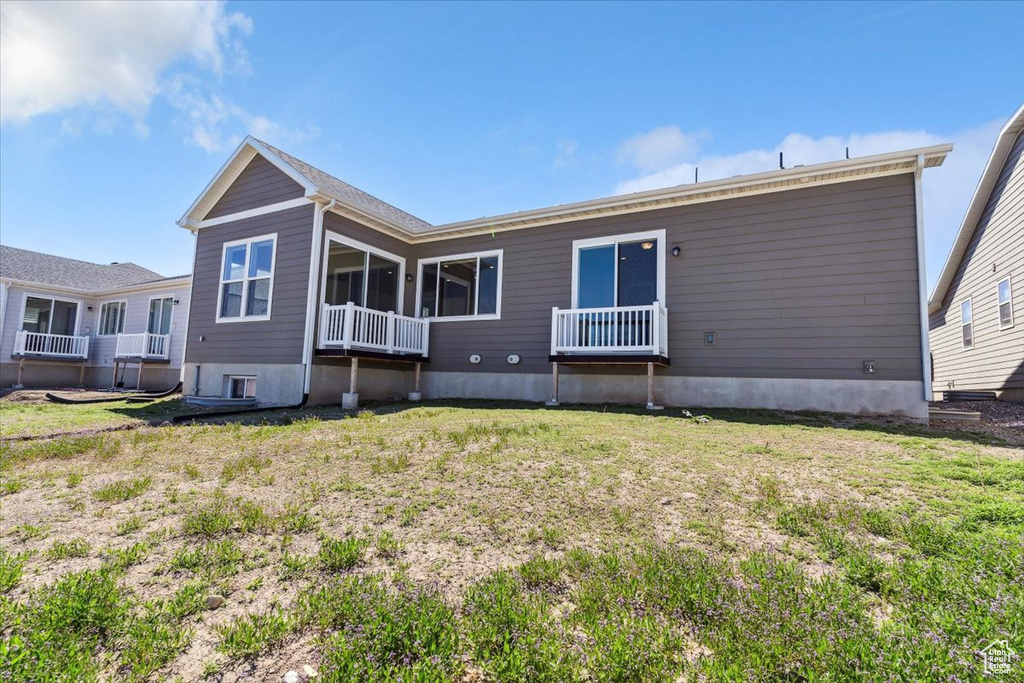 Rear view of property with a lawn