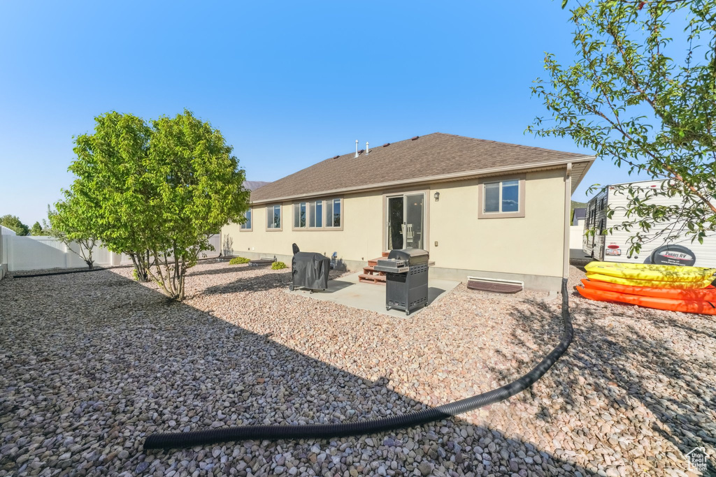 Rear view of property featuring a fenced backyard, a patio, stucco siding, and roof with shingles