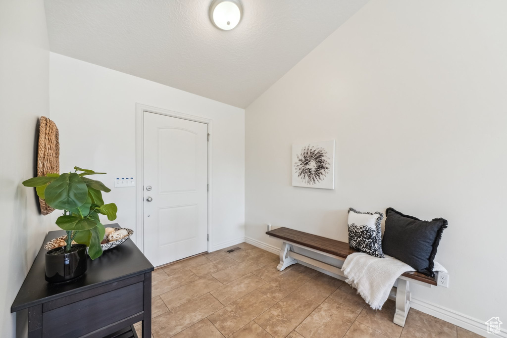 Entryway featuring baseboards and vaulted ceiling