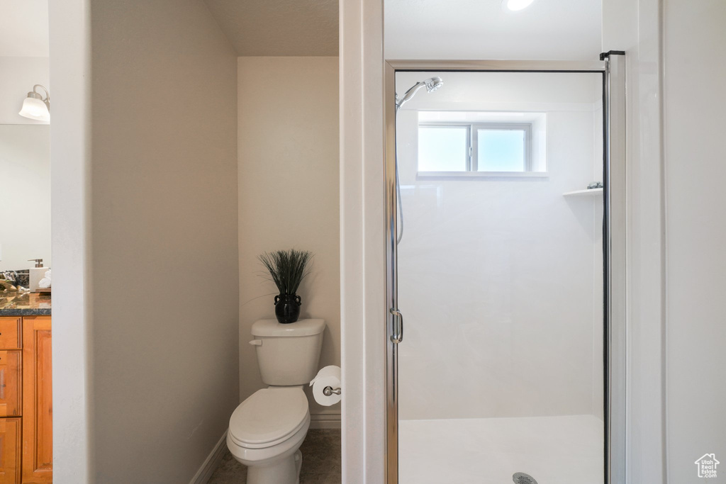 Bathroom with vanity, a stall shower, and toilet
