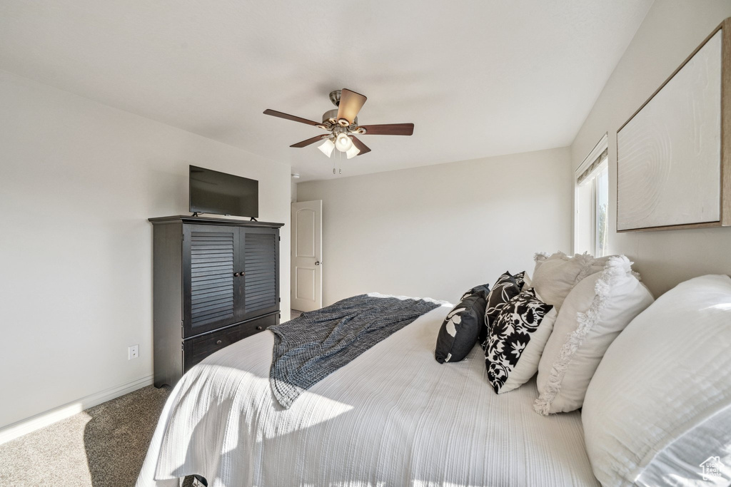 Carpeted bedroom with baseboards and a ceiling fan