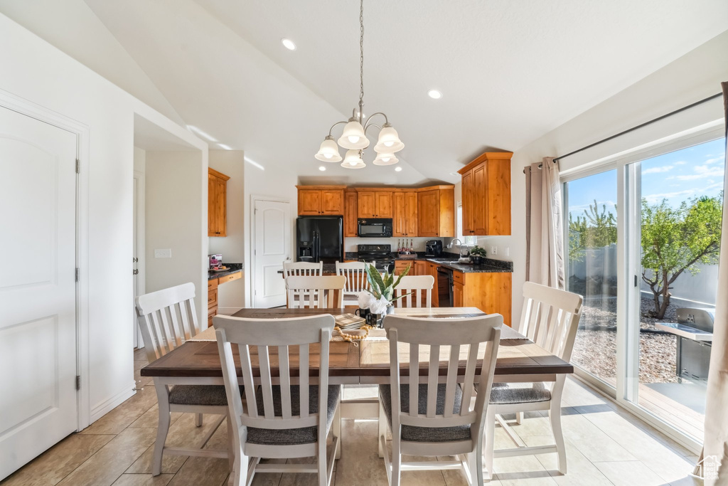 Dining space featuring light tile patterned floors, vaulted ceiling, recessed lighting, and a notable chandelier