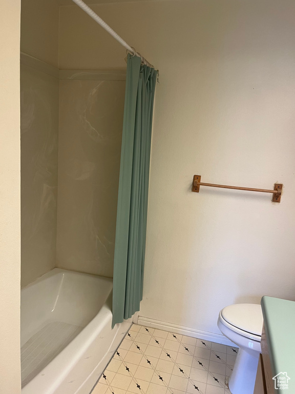 Full bath with toilet and baseboards