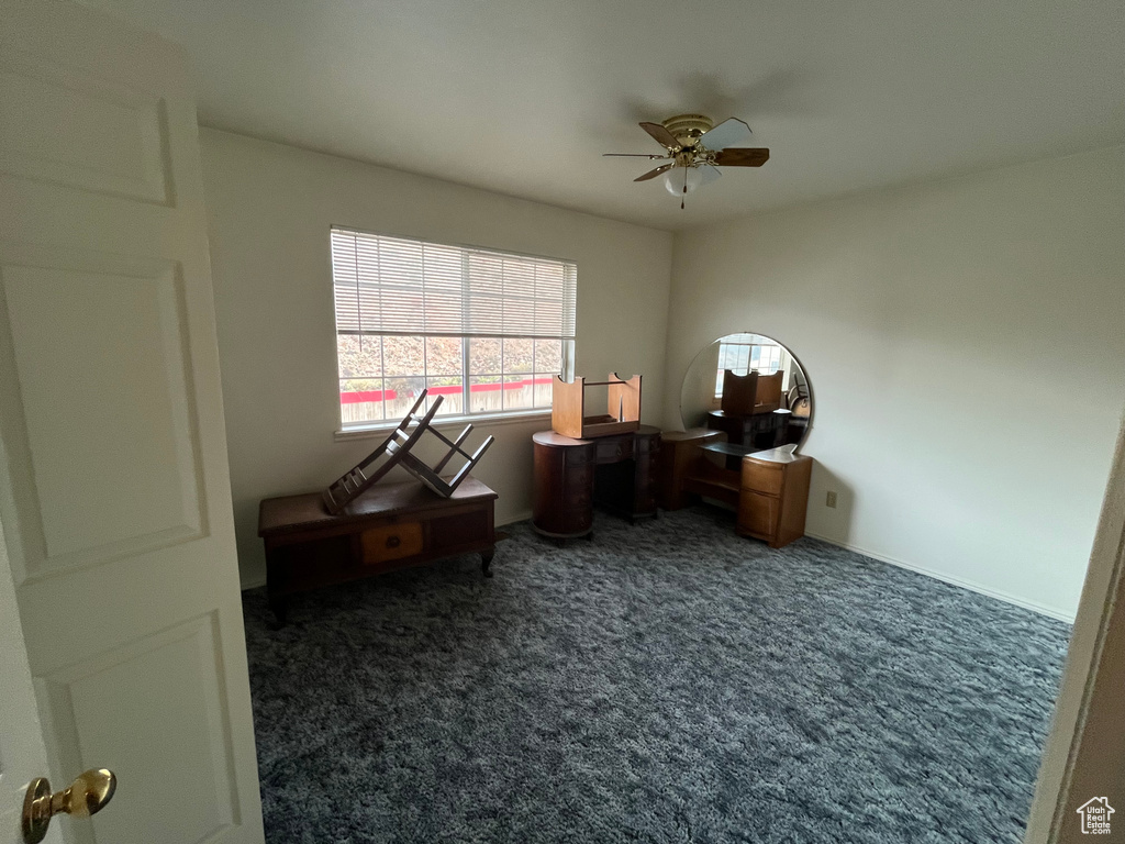 Carpeted office space with a ceiling fan