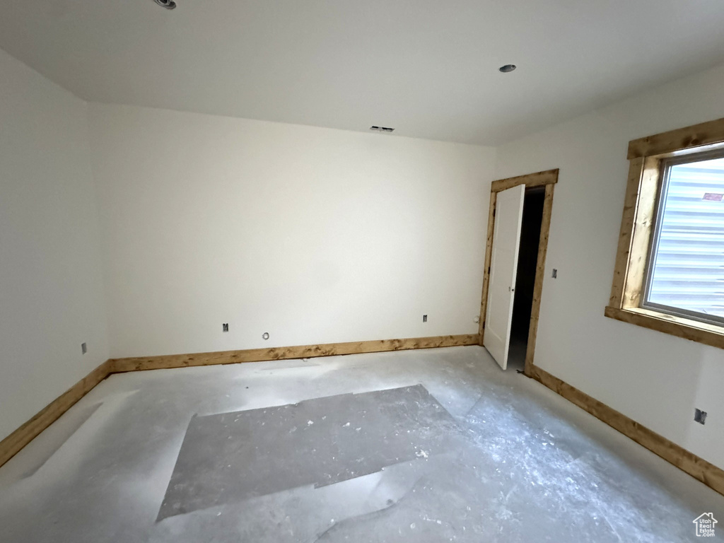 Spare room with unfinished concrete floors and baseboards