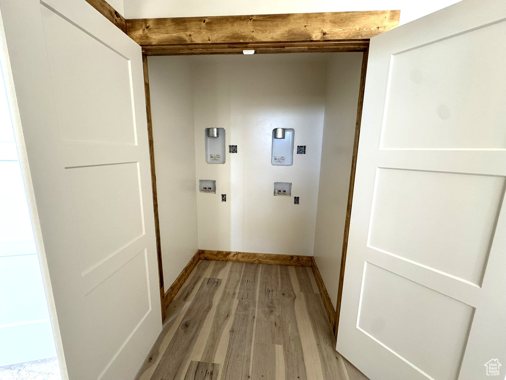 Washroom with laundry area, baseboards, hookup for a washing machine, light wood-type flooring, and hookup for an electric dryer