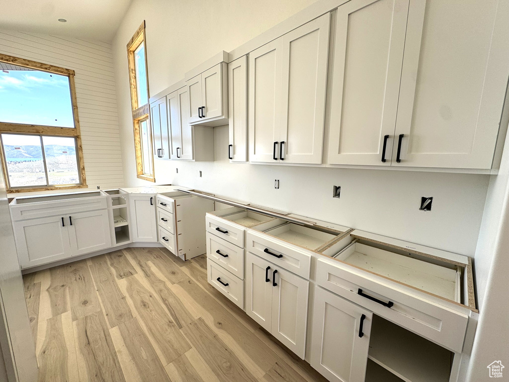 Kitchen with white cabinets and light wood-style flooring