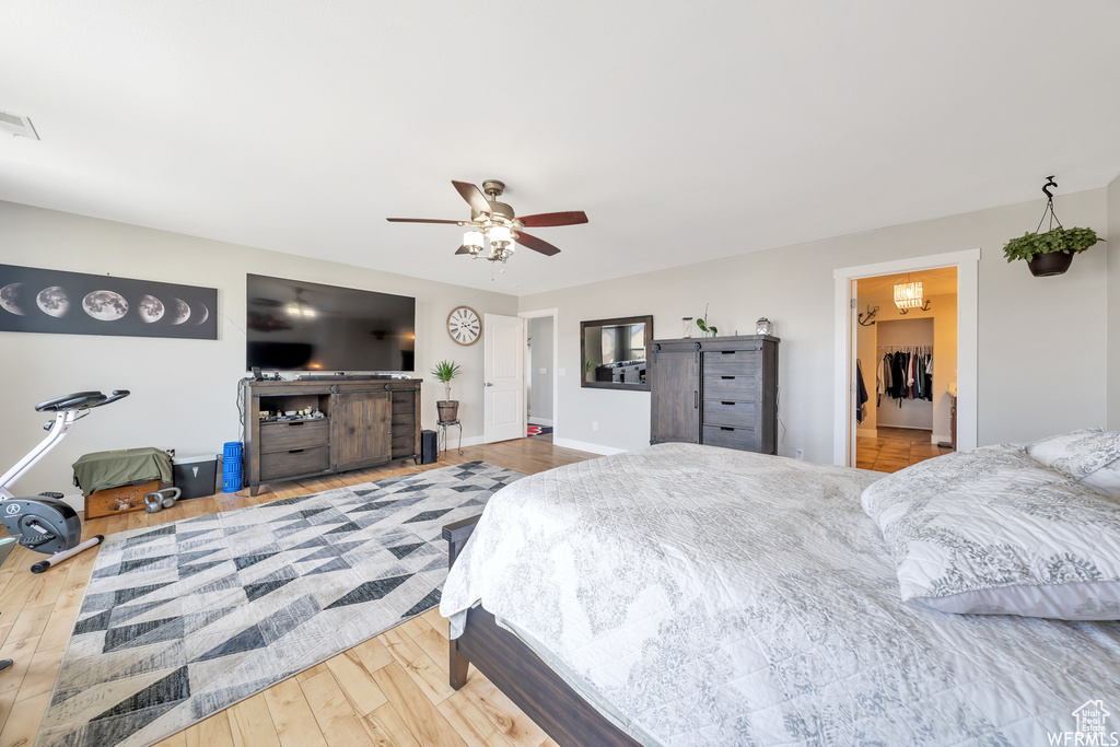 Bedroom featuring wood finished floors, ceiling fan, and a walk in closet
