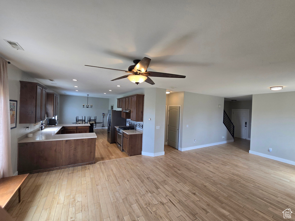 Kitchen with visible vents, ceiling fan, light wood finished floors, open floor plan, and appliances with stainless steel finishes