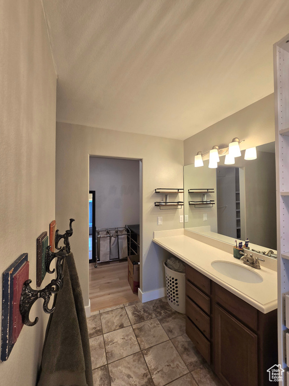 Bathroom with vanity, baseboards, and tile patterned floors