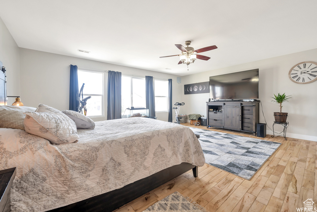Bedroom with wood finished floors, a ceiling fan, and baseboards