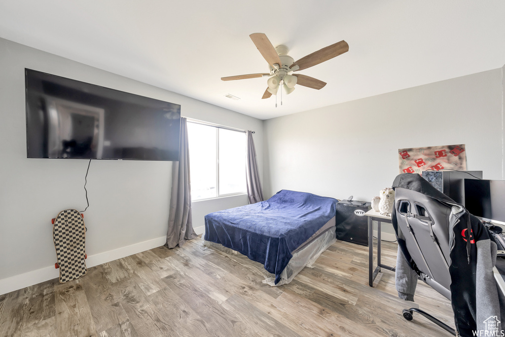 Bedroom with baseboards, visible vents, ceiling fan, and light wood-style floors